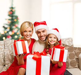 Image showing smiling family giving many gift boxes