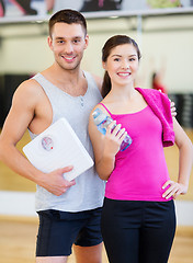 Image showing two smiling people with scale in the gym