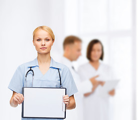 Image showing smiling female doctor or nurse with sclipboard