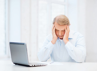 Image showing stressed old man filling a form at home