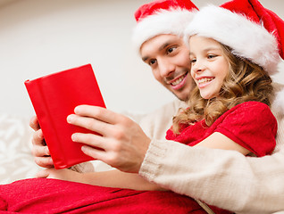 Image showing smiling father and daughter reading book