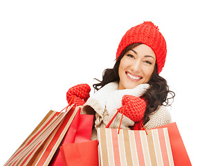 Image showing smiling woman in warm clothers with shopping bags