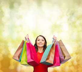 Image showing woman in red dress with colorful shopping bags