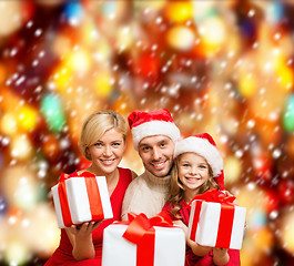 Image showing smiling family giving many gift boxes