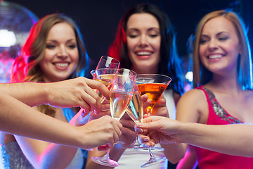 Image showing three smiling women with cocktails and disco ball