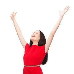 Image showing smiling young woman in red dress waving hands