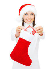 Image showing smiling woman with small giftbox and stocking