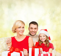 Image showing smiling family holding many gift boxes