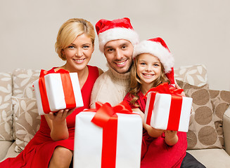 Image showing smiling family giving many gift boxes