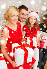 Image showing smiling family holding many gift boxes