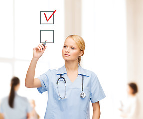 Image showing doctor or nurse drawning checkmark into checkbox