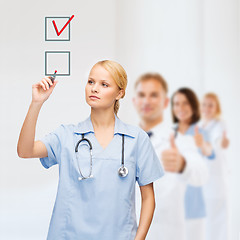 Image showing doctor or nurse drawning checkmark into checkbox