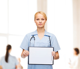 Image showing smiling female doctor or nurse with sclipboard