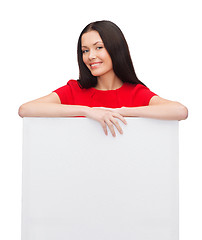 Image showing smiling young woman with blank white board