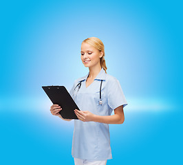 Image showing smiling female doctor or nurse with clipboard