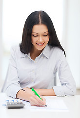 Image showing businesswoman or student working with calculator