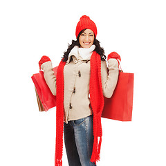 Image showing smiling woman in warm clothers with shopping bags