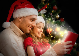 Image showing smiling father and daughter reading book