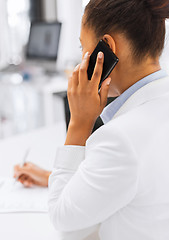 Image showing businesswoman with smartphone in office