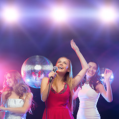 Image showing three smiling women dancing and singing karaoke