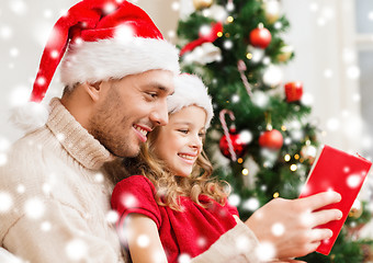 Image showing smiling father and daughter reading book