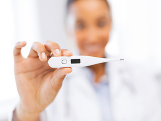 Image showing female doctor holding thermometer