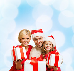 Image showing smiling family giving many gift boxes