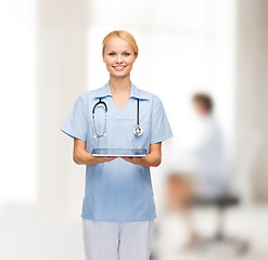 Image showing smiling female doctor or nurse with tablet pc