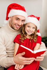 Image showing smiling father and daughter reading book