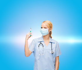 Image showing female doctor or nurse in mask holding syringe