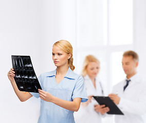 Image showing serious doctor or nurse looking at x-ray