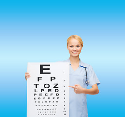 Image showing smiling female doctor or nurse with eye chart