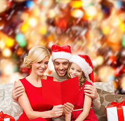 Image showing smiling family reading postcard