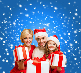 Image showing smiling family giving many gift boxes