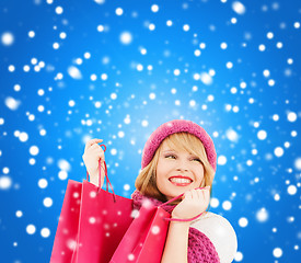 Image showing woman in pink hat and scarf with shopping bags