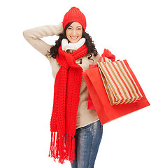 Image showing smiling woman in warm clothers with shopping bags