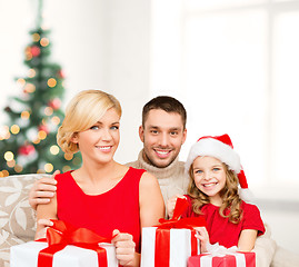 Image showing smiling family holding many gift boxes