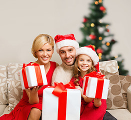 Image showing smiling family giving many gift boxes