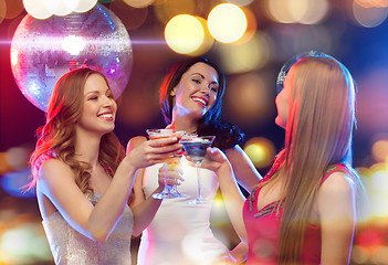 Image showing three smiling women with cocktails and disco ball