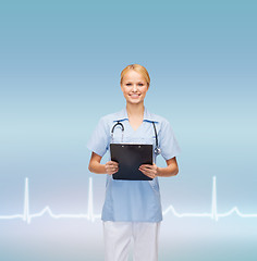 Image showing smiling female doctor or nurse with clipboard