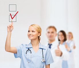 Image showing doctor or nurse drawning checkmark into checkbox