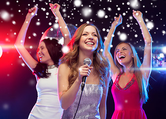 Image showing three smiling women dancing and singing karaoke