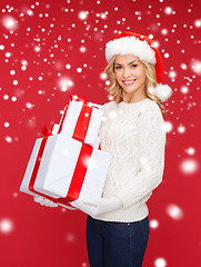 Image showing woman in santa helper hat with many gift boxes