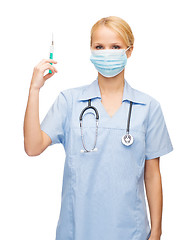 Image showing female doctor or nurse in mask holding syringe