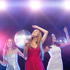 Image showing three smiling women dancing and singing karaoke