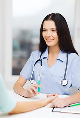 Image showing smiling female doctor or nurse with syringe