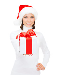 Image showing woman in santa helper hat holding gift box