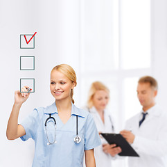 Image showing doctor or nurse drawing checkmark into checkbox