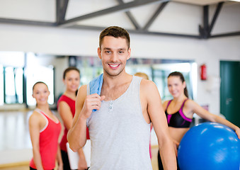 Image showing smiling man standing in front of the group in gym