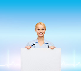 Image showing smiling female doctor or nurse with blank board